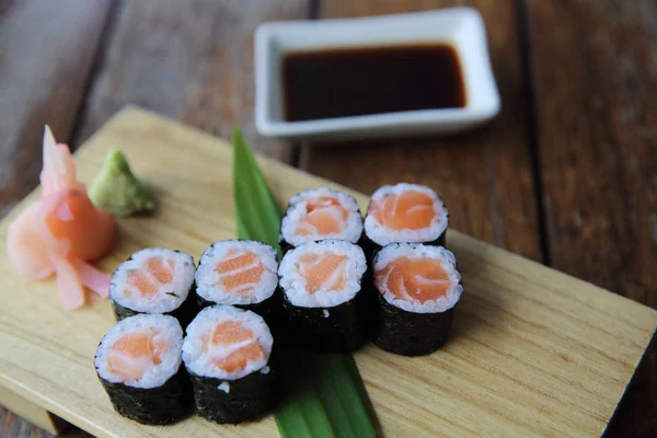 Salmón maki sushi sobre fondo de madera, comida japonesa —  Fotos de Stock
