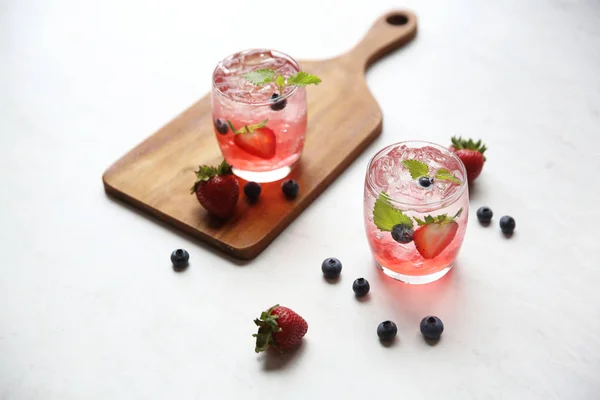 Cocktail di succo di fragola con ghiaccio e menta su tono bianco amd wo — Foto Stock