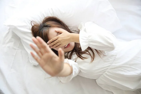 Asiatico giovane donna wake up con cuscino in bianco stanza — Foto Stock
