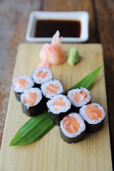 Sushi de maki de salmão em fundo de madeira, comida japonesa — Fotografia de Stock