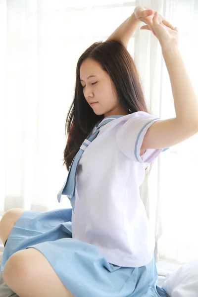 School girl wake up from bed on white room — Stock Photo, Image