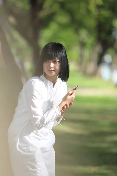 关于智能手机肖像与 g 亚洲年轻女人听音乐 — 图库照片