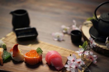 Suşi Set sashimi ve suşi rulo çay ile ahşap arka plan üzerinde