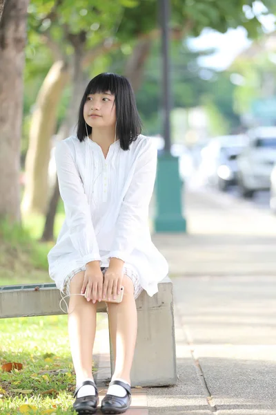 Mujer joven asiática escuchando música en retrato de teléfono inteligente con g —  Fotos de Stock