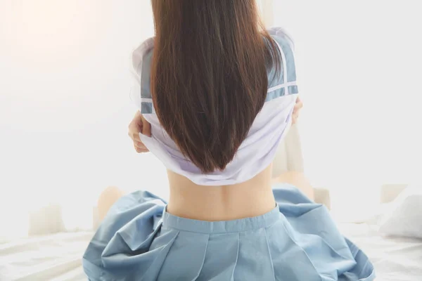 白い部屋に服を着る女子高生 — ストック写真