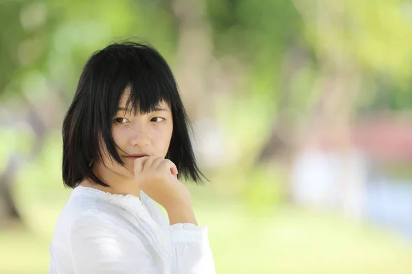 Asian young woman portrait with the tree background — Stock Photo, Image
