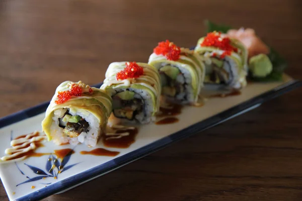 Aguacate sushi maki sobre fondo de madera, comida japonesa —  Fotos de Stock