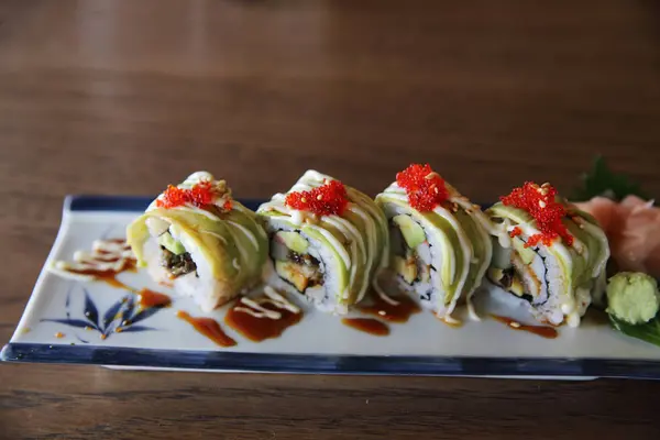 Aguacate sushi maki sobre fondo de madera, comida japonesa —  Fotos de Stock