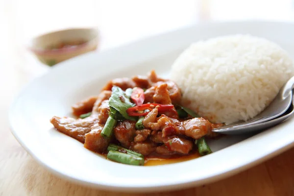 Cerdo frito con curry tailandés y arroz sobre fondo de madera, tailandés fo —  Fotos de Stock