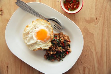 Kızarmış domuz eti ve fesleğen ile pirinç ilave edin ve ahşap arka plan t üzerinde yumurta