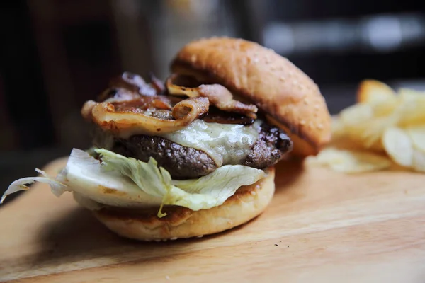 Hovězí hamburger na pozadí dřeva — Stock fotografie