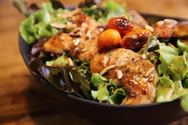 Ensalada de pollo sobre fondo de madera en restaurante lgiht — Foto de Stock