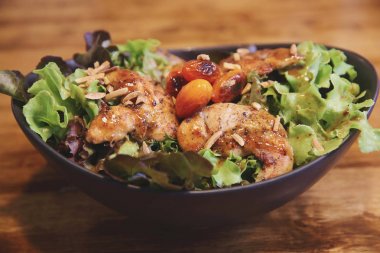 Restoran lgiht içinde ahşap arka plan üzerinde Tavuk salatası