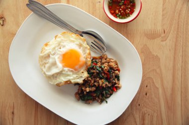 Kızarmış domuz eti ve fesleğen ile pirinç ilave edin ve ahşap arka plan t üzerinde yumurta