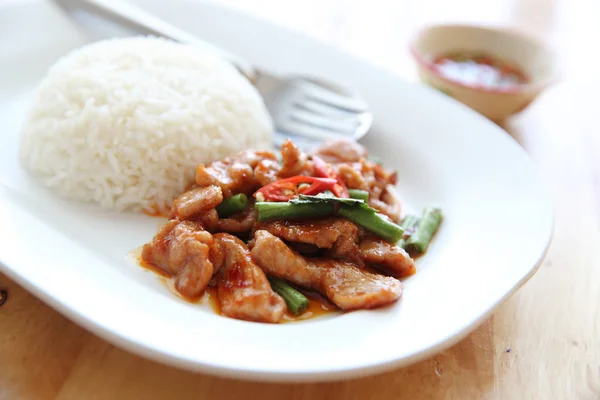 Babi goreng dengan kari thai dan nasi di kayu latar belakang, Thai fo — Stok Foto