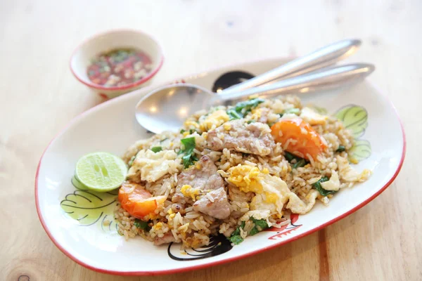 Schweinefleisch gebratenen Reis mit Limette auf Holz Hintergrund, thailändische Küche — Stockfoto