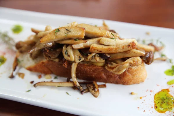 Croccante pane bianco tostato con funghi su scheda fondo legno — Foto Stock