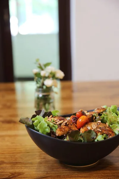 Chicken salad on wood background in restaurant lgiht