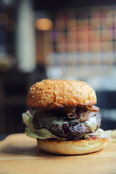 Hovězí hamburger na pozadí dřeva — Stock fotografie