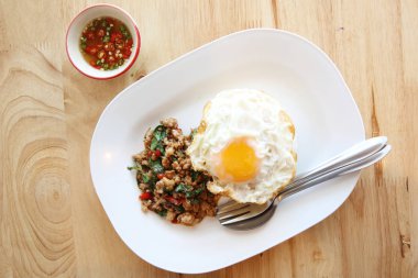 Kızarmış domuz eti ve fesleğen ile pirinç ilave edin ve ahşap arka plan t üzerinde yumurta