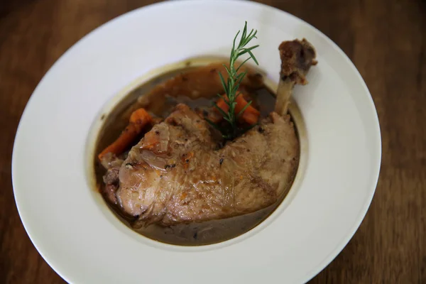 Coq au vin, chicken stewed in red wine with carrots and potatoes — Stock Photo, Image