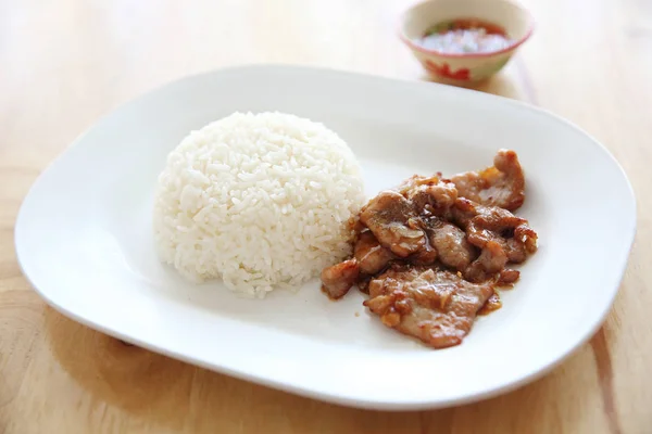 Porco frito com alho e arroz em fundo de madeira, comida tailandesa — Fotografia de Stock