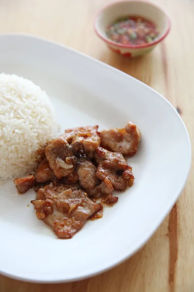 Cerdo frito con ajo y arroz sobre fondo de madera, comida tailandesa —  Fotos de Stock