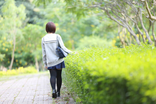 Portrait of Japanese school girl with countryside park