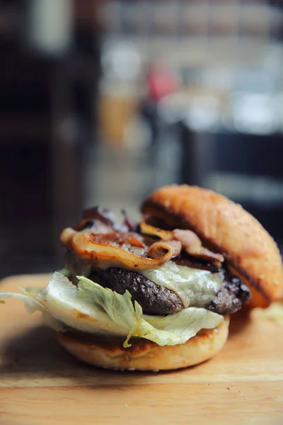 Hovězí hamburger na pozadí dřeva — Stock fotografie