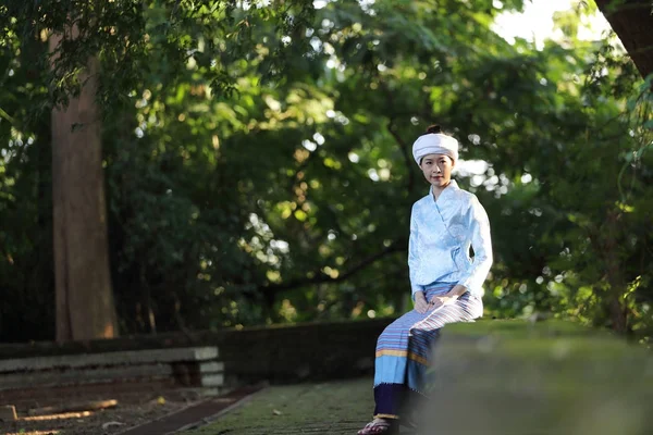 Geleneksel Tay elbise ile Taylandlı genç kadın portresi oturmak 