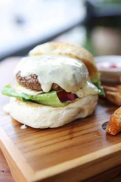 Hamburger de boeuf au fromage et feux sur fond de bois — Photo