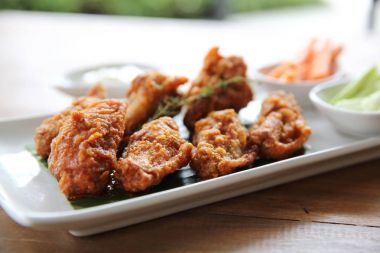 Baharatlı tavuk kanadı Barbekü tavuk wo üzerinde salatalık ve havuç ile