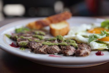 Izgara sığır eti biftek ile kızarmış ekmek, kızarmış yumurta ve sebze üzerine 
