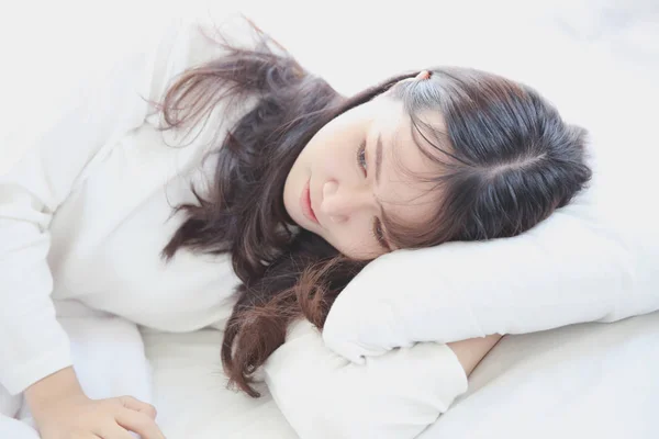 Wanita muda Asia bangun di tempat tidur dengan nada putih — Stok Foto