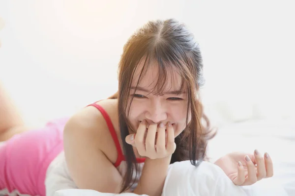Asian young woman wake up on bed in white tone — Stock Photo, Image