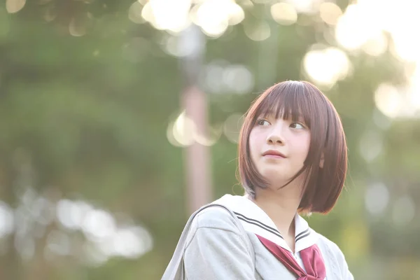 Portrait of Japanese school girl with countryside park