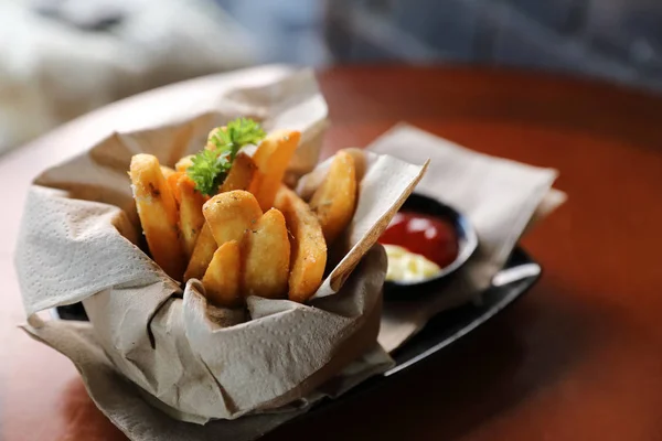 Papas fritas en estilo vintage sobre fondo de madera — Foto de Stock