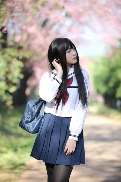 Japanisch Schule Mädchen Kleid mit Sakura Blume Natur Gehweg — Stockfoto