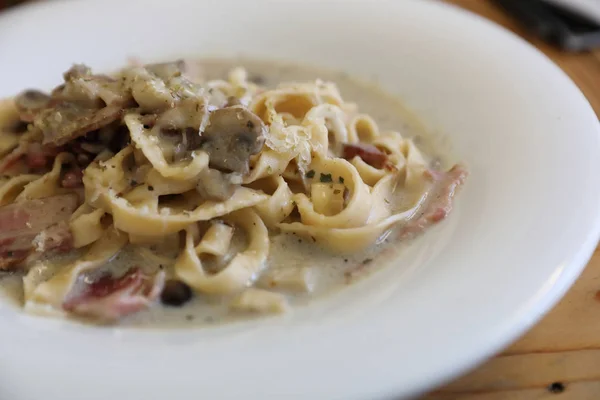 Makaron fettuccine alfredo białym sosie z szynki boczek i grzyby — Zdjęcie stockowe