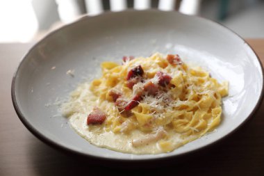 Spagetti carbonara beyaz sos ahşap arka planda pastırma ile