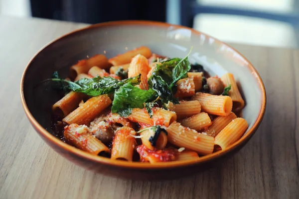 Pasta con salchicha en salsa de tomate sobre fondo de madera, italiano —  Fotos de Stock