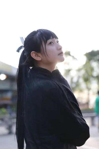 Young pretty girl wearing black cotton sweatshirt outdoor backgo — Stock Photo, Image