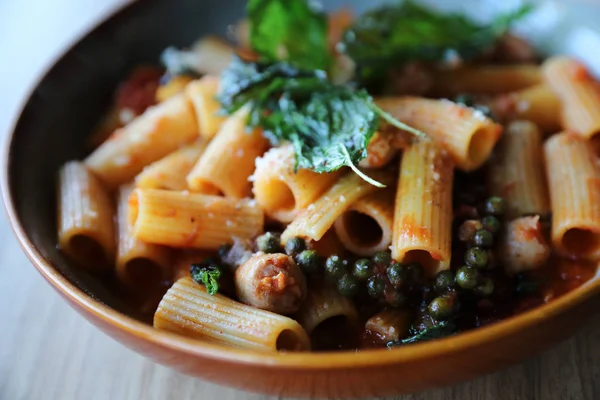 Pasta con salchicha en salsa de tomate sobre fondo de madera, italiano —  Fotos de Stock