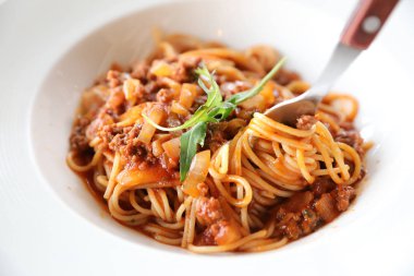 Parmesan peyniri ve fesleğenle süslenmiş kıyma ve domates soslu spagetti bolonez, İtalyan yemeği.