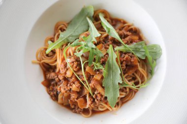 Parmesan peyniri ve fesleğenle süslenmiş kıyma ve domates soslu spagetti bolonez, İtalyan yemeği.