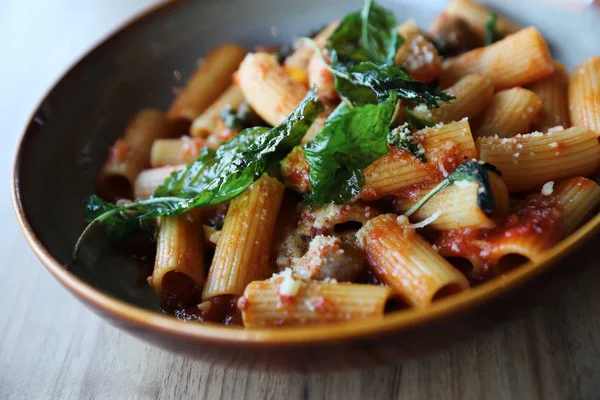 Pasta con salchicha en salsa de tomate sobre fondo de madera, italiano —  Fotos de Stock