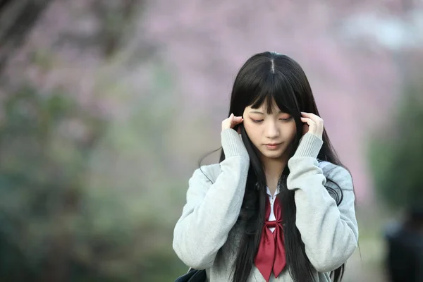 Japonés escuela chica vestido buscando sakura flor naturaleza pasarela —  Fotos de Stock