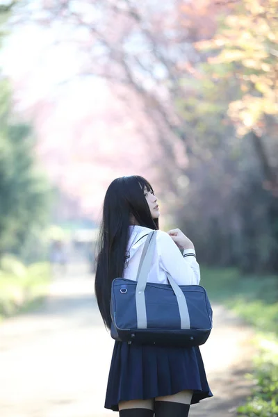 Japonés escuela chica vestido buscando sakura flor naturaleza pasarela —  Fotos de Stock