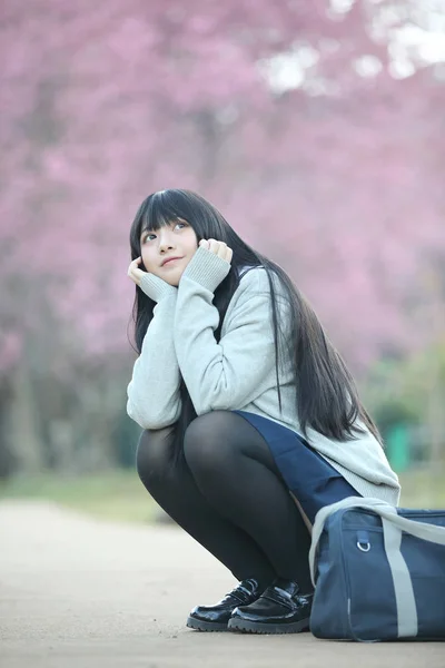 Japońskie uczennice dress siedzi z sakura kwiat natura wal — Zdjęcie stockowe