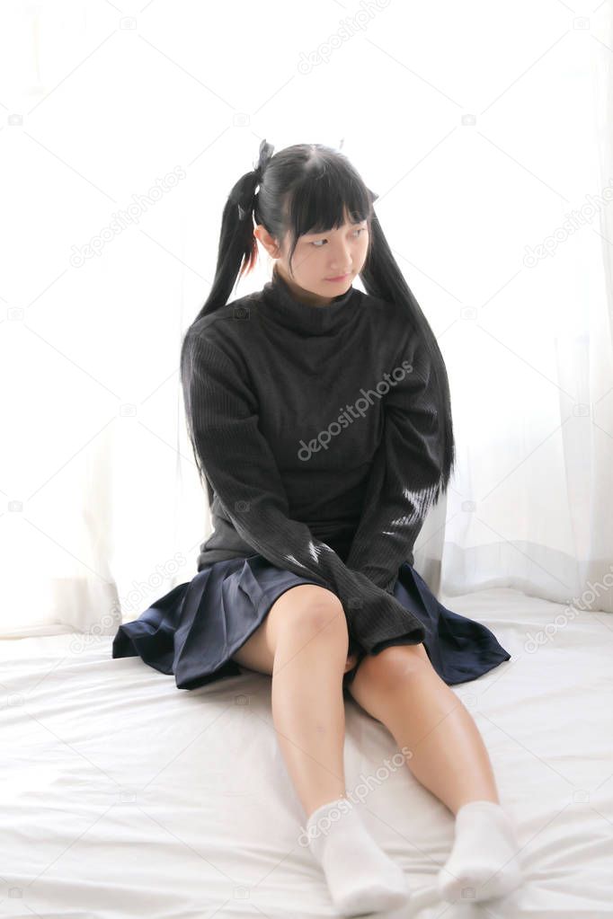 Young pretty girl wearing black cotton sweatshirt on bedroom whi